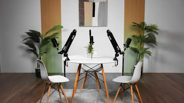 Round table set for four speakers with boom-arm microphones